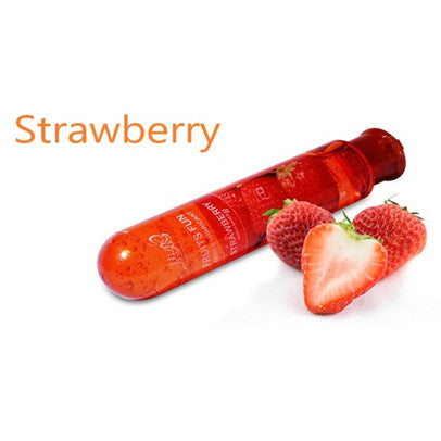 Strawberry lubricant bottle beside strawberries