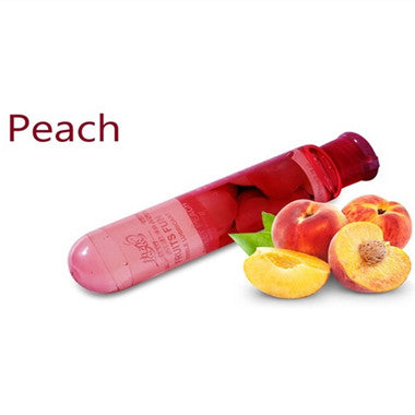 Peach lubricant bottle beside peaches