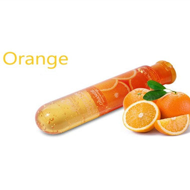 Orange lubricant bottle beside oranges