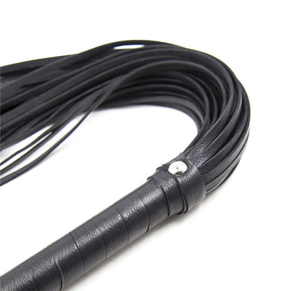 Close-up of black flogger handle and tails