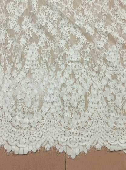 Close-up of white floral lace and scalloped hem