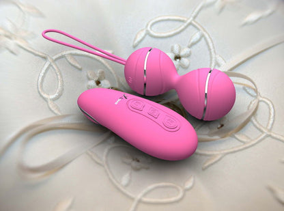 Light pink vibrating balls and remote on fabric