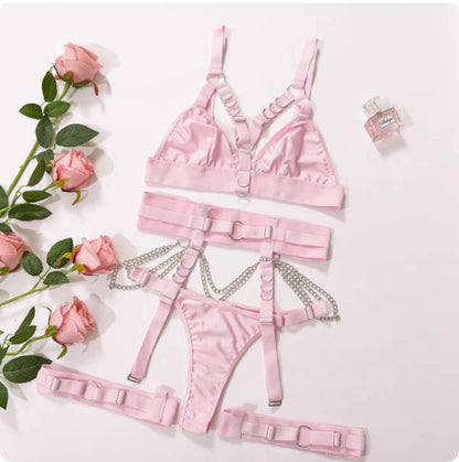 Pink harness lingerie components displayed flat
