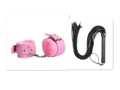 Pink cuffs beside black flogger