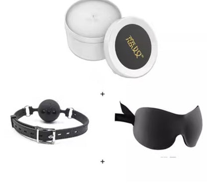 White candle with black eye mask and ball gag